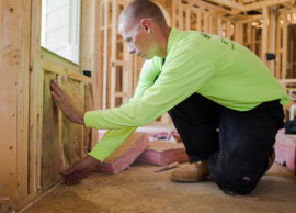 insulation contractor installing insulation in unfinished home