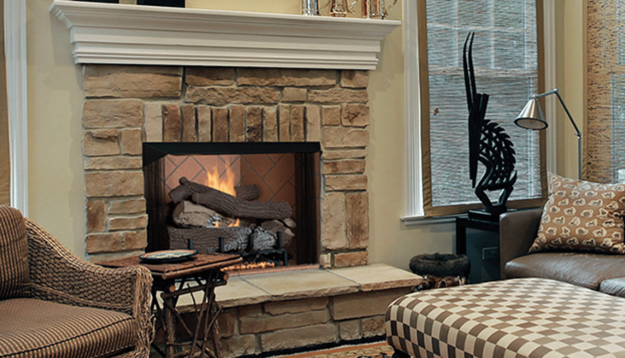 ventless fireplace with wooden logs on traditional stone mantle