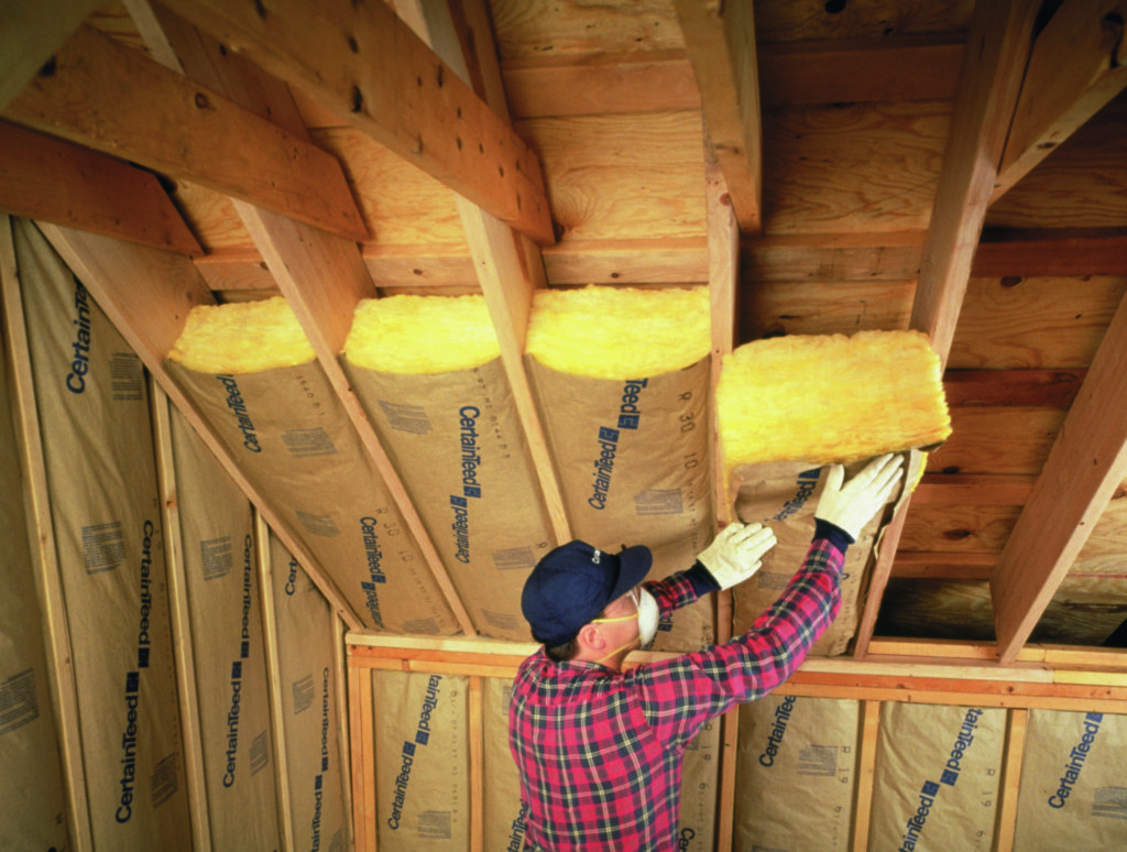 CertainTeed fiberglass batt insulation being installed in attic ceiling